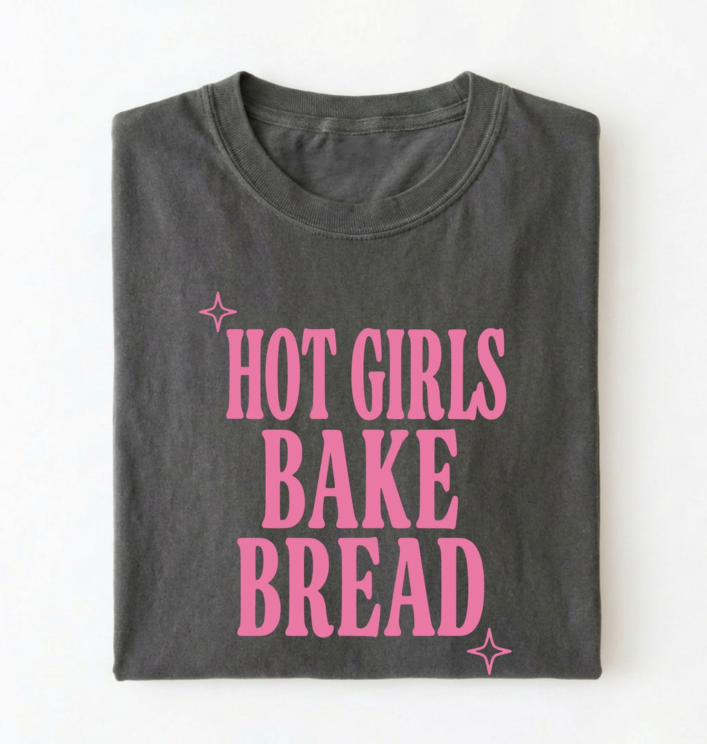 Flat lay of a pepper hot girls bake bread shirt with pink text funny sourdough baker gift black t-shirt on a white background 