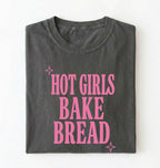 Flat lay of a pepper hot girls bake bread shirt with pink text funny sourdough baker gift black t-shirt on a white background 