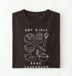 Flat lay of a Funny hot girls bake sourdough shirt with bread and baking tools illustration on brown tee on a white background 
