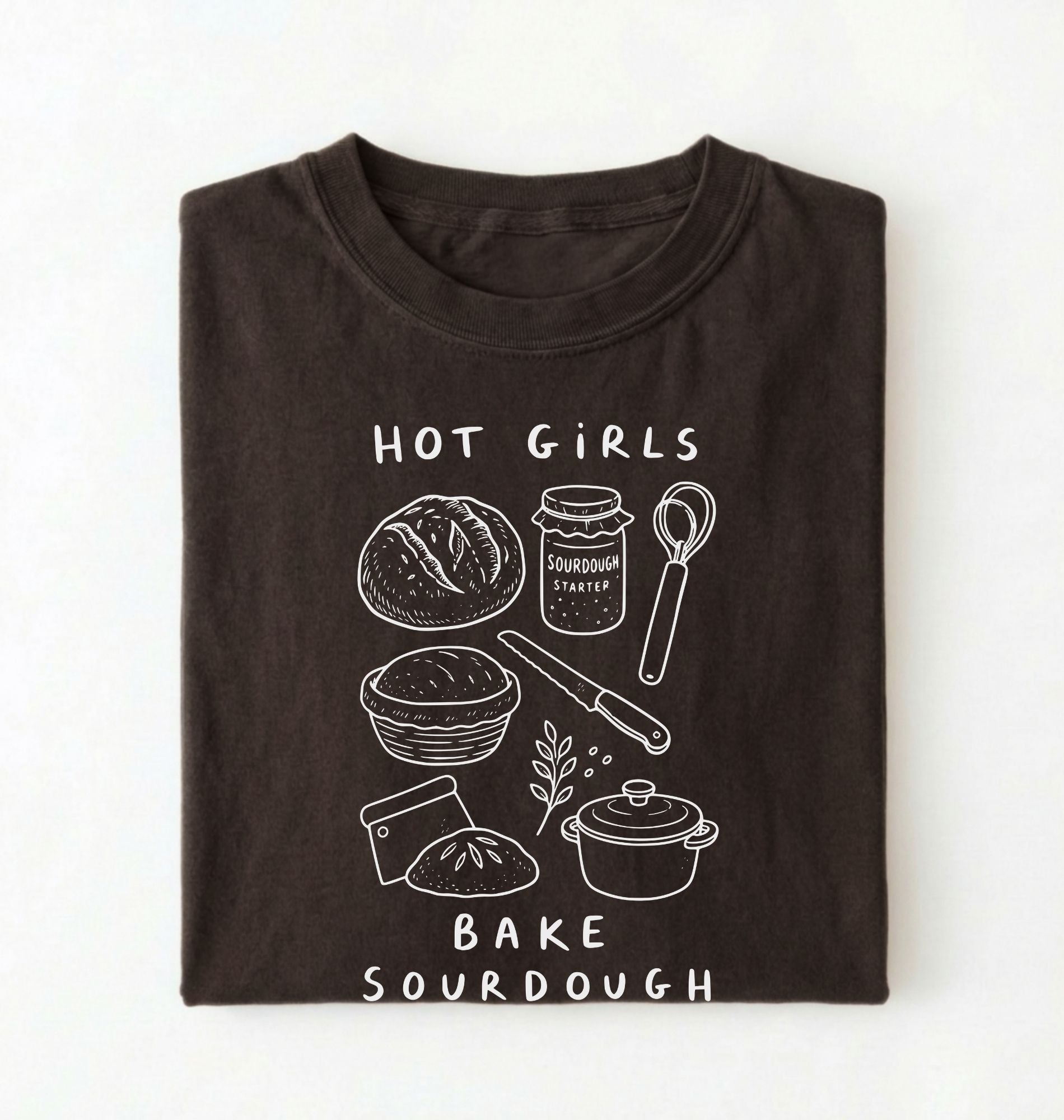 Flat lay of a Funny hot girls bake sourdough shirt with bread and baking tools illustration on brown tee on a white background 