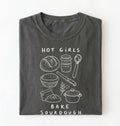 Flat lay of a Funny hot girls bake sourdough shirt with bread and baking tools illustration on pepper tee on a white background 