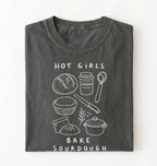 Flat lay of a Funny hot girls bake sourdough shirt with bread and baking tools illustration on pepper tee on a white background 