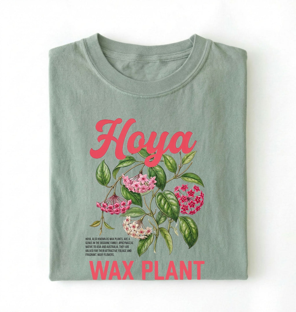 Flat lay of a bay t-shirt featuring a detailed botanical illustration labeled “Hoya Wax Plant” with flowers and leaves.
