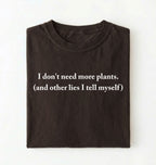 Flat lay of a espresso cozy crewneck t-shirt on a white background with a white text displaying the phrase “I don’t need more plants (and other lies I tell myself)” centered on the front on a white background 