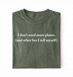 Flat lay of a moss cozy crewneck t-shirt on a white background with a white text displaying the phrase “I don’t need more plants (and other lies I tell myself)” centered on the front