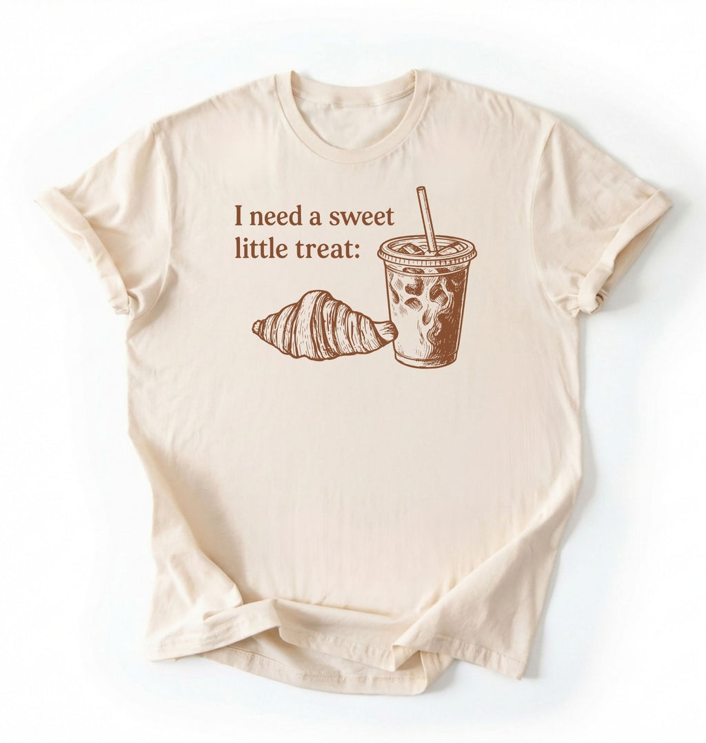 Flat lay of a Cute coffee and croissant shirt with cozy bakery aesthetic on black tee on a cream background 