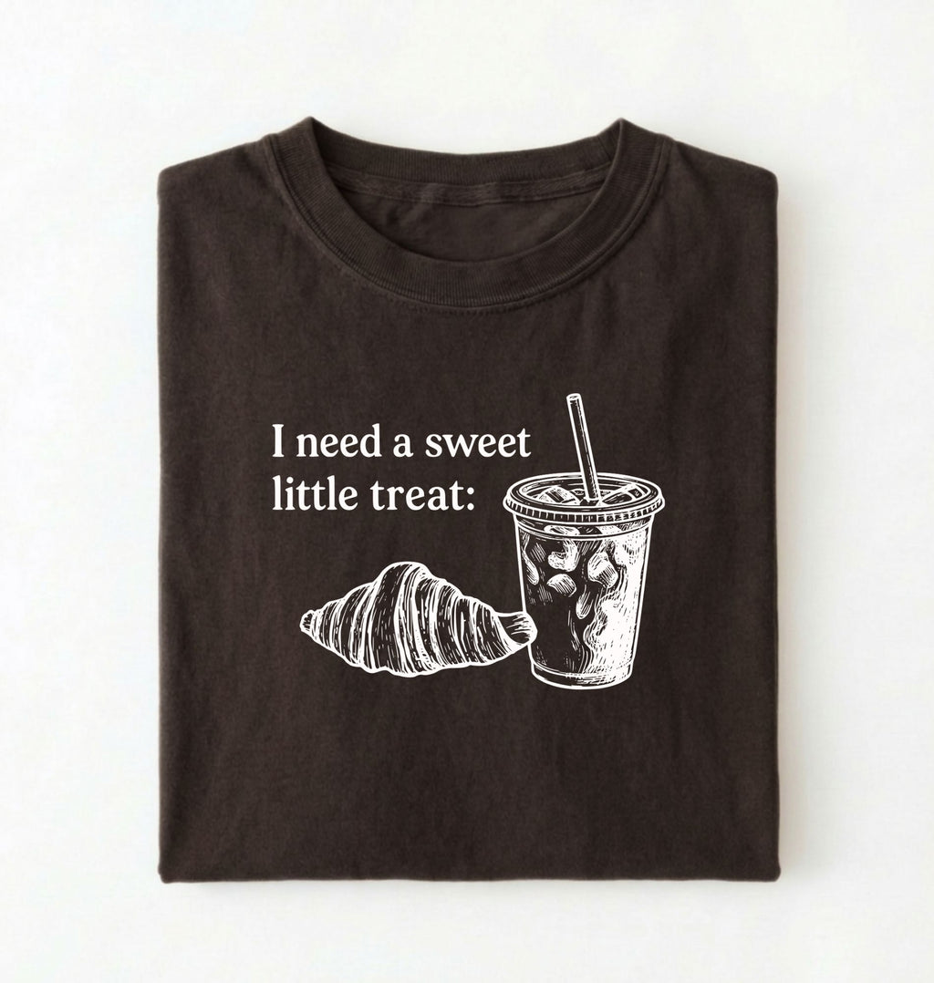 Flat lay of a Cute coffee and croissant shirt with cozy bakery aesthetic on pepper tee on a white background 