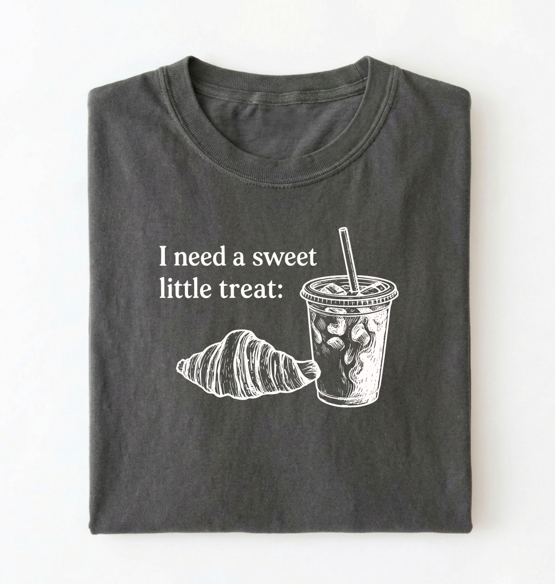 Flat lay of a Cute coffee and croissant shirt with cozy bakery aesthetic on pepper tee on a white background 