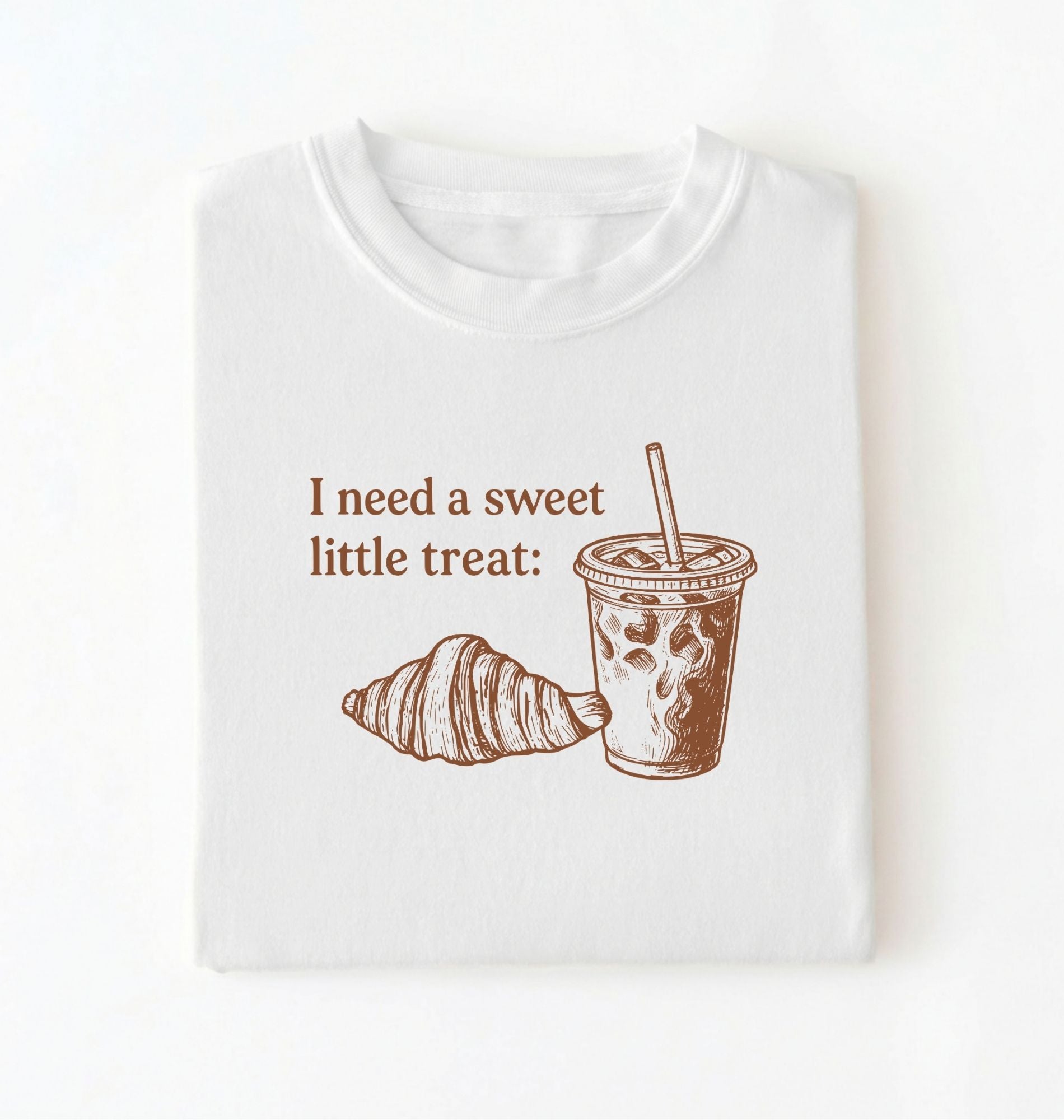 Flat lay of a Cute coffee and croissant shirt with cozy bakery aesthetic on white tee on a white background 