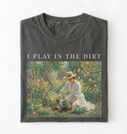 Flat lay of a grey t-shirt featuring a vintage-style garden painting with text reading “I Play In The Dirt.” On a white background 