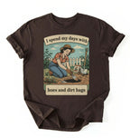Flat lay of a dark chocolate Funny gardening shirt with hoes and dirt bags text perfect for gardeners and plant lovers with humor on a white background