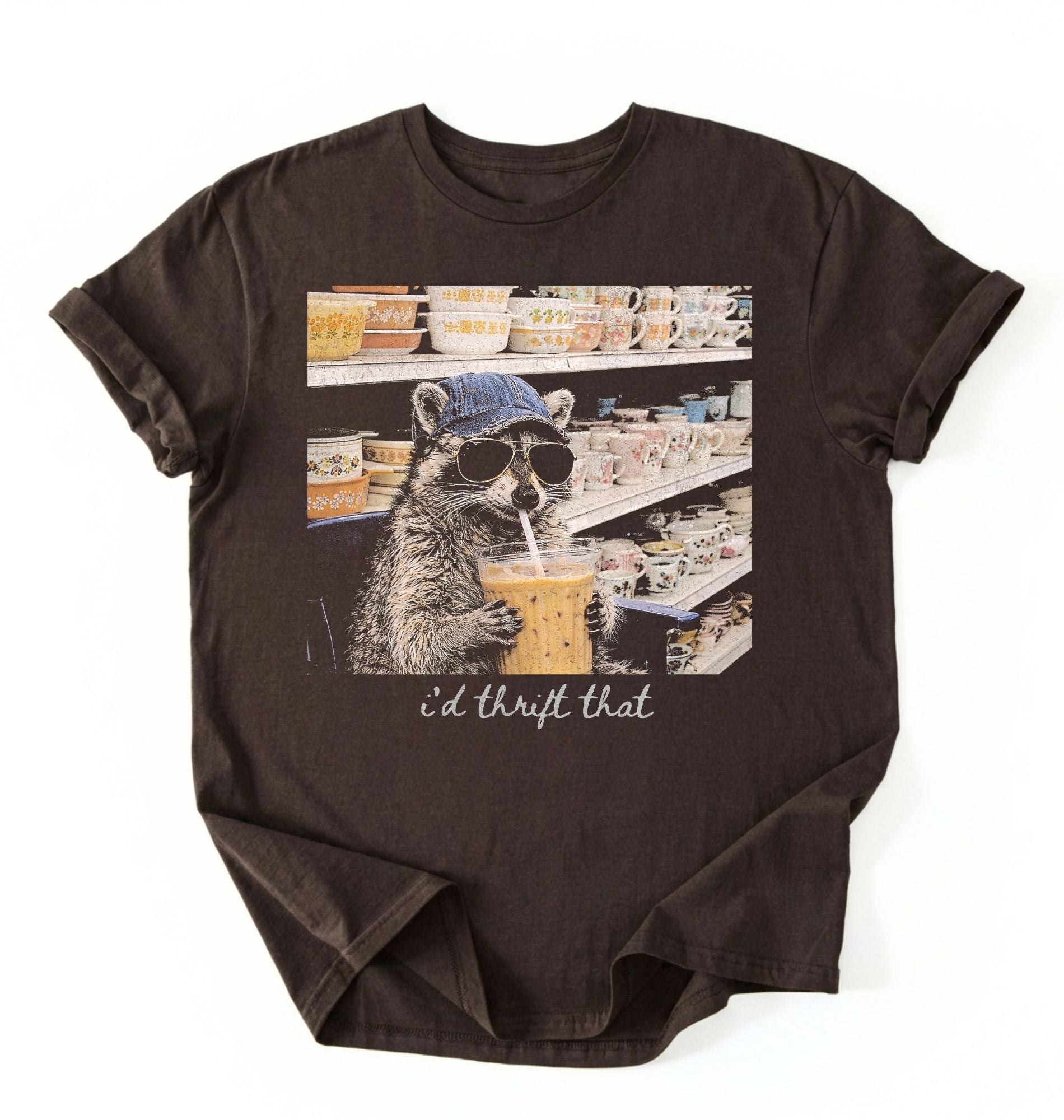 Flat lay of a id thrift that raccoon shirt dark chocolate funny thrift shopping t shirt vintage lover gift on a white background 