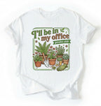 Flat lay of a white t-shirt featuring illustrated potted plants, tools, and text reading “I’ll Be In My Office Garden Club on a white background