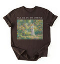 Flat lay of a espresso t-shirt featuring a vintage garden painting of a woman tending flowers with text reading “I’ll Be In My Office.” On a white background 