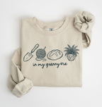 Flat lay of a sand crewneck sweatshirt with line drawings of gardening items and text reading “in my granny era.”