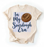 Flat lay of a natural in my sourdough era shirt white funny baking t shirt bread lover gift cottagecore style on a white background