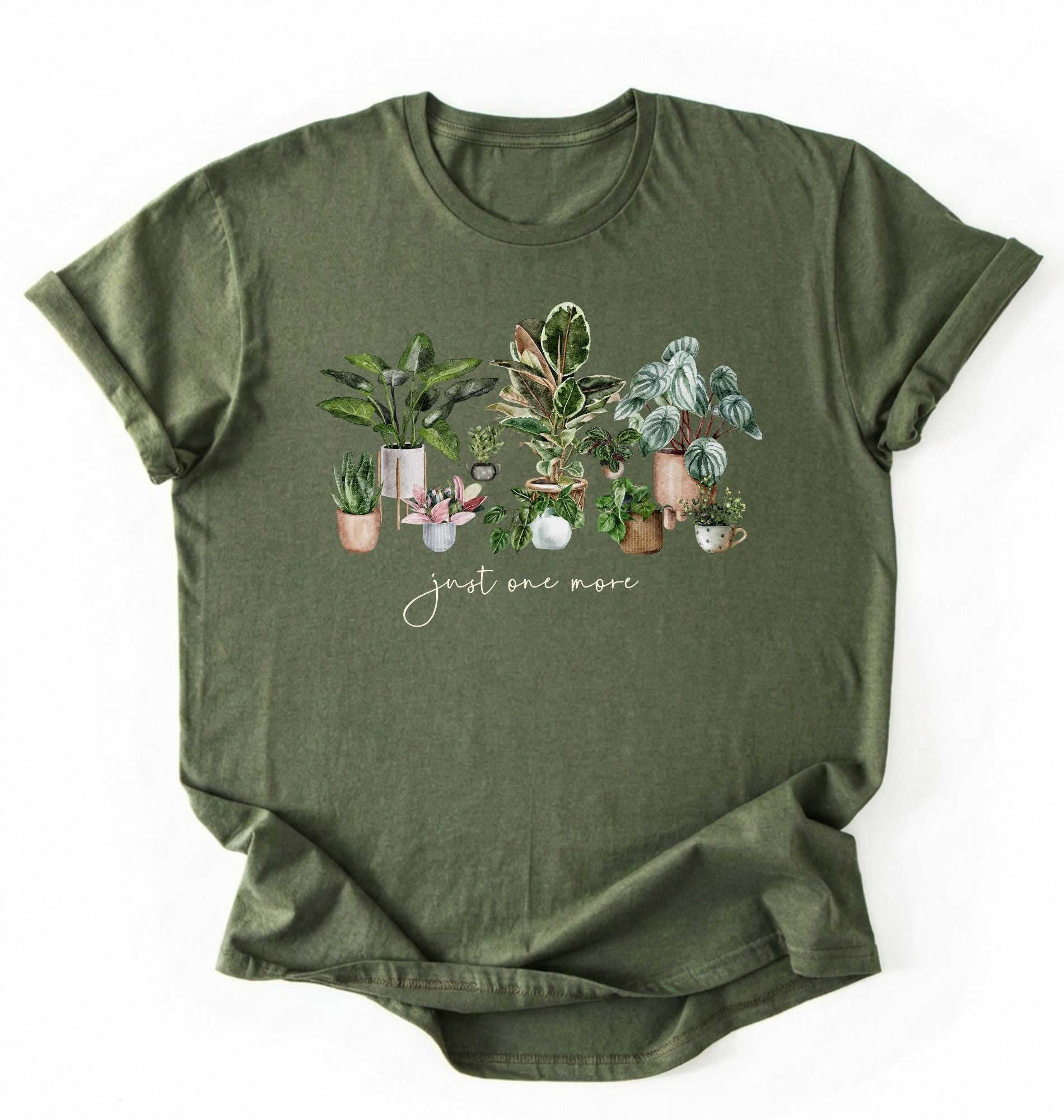 Flat lay of Military Green t-shirt with plant illustrations and 'just one more' text on a white background