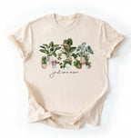 Flat lay of Natural t-shirt with plant illustrations and 'just one more' text on a white background