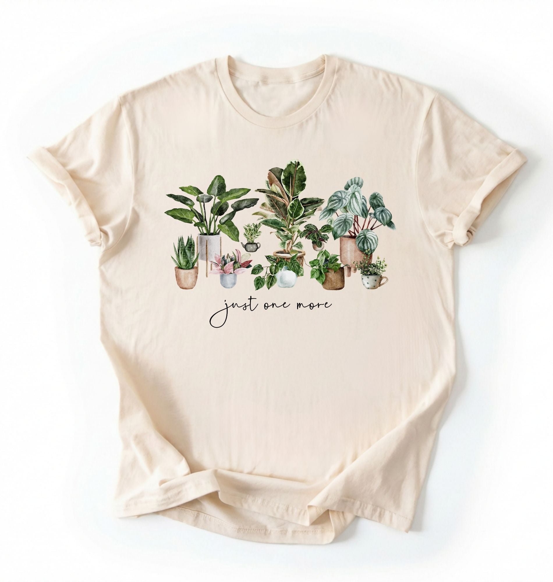 Flat lay of Natural t-shirt with plant illustrations and 'just one more' text on a white background