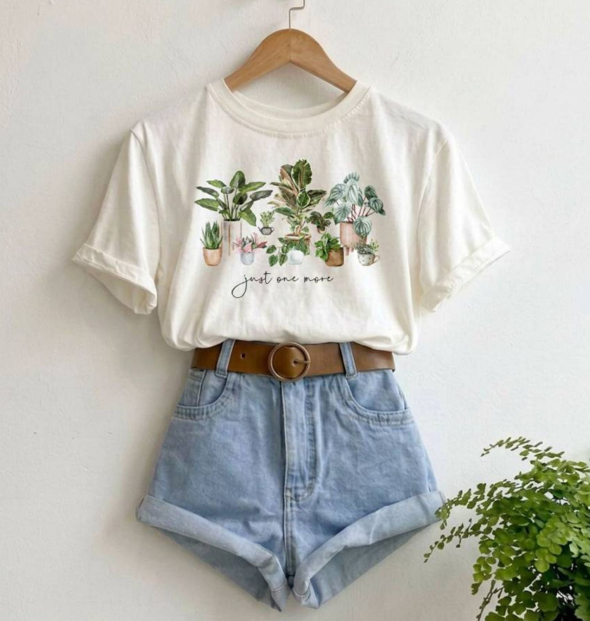 white hanging shirt with watercolor plants and text that says "just one more"