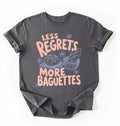 Flat lay of a charcoal less regrets more baguettes shirt brown funny baking t shirt bread lover gift foodie humor design on a white background 