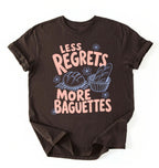 Flat lay of a dark chocolate less regrets more baguettes shirt brown funny baking t shirt bread lover gift foodie humor design on a white background 