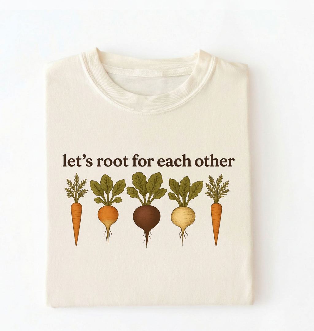 Flat lay of an ivory t shirt with the text Let’s root for each other gardening t-shirt with illustrated root vegetables, perfect gardener gift on a white background