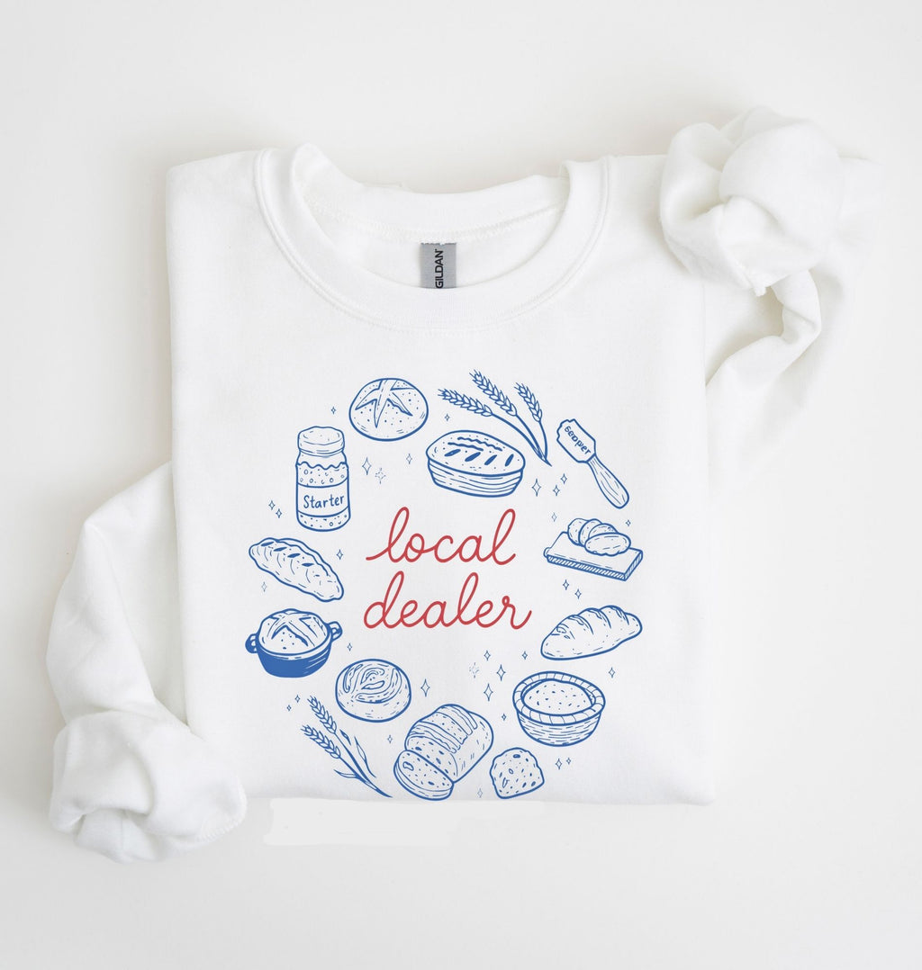 Flat lay of a white Bakery themed crewneck featuring bread and sourdough starter graphics on a white background 