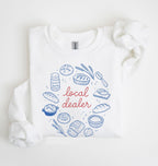 Flat lay of a white Bakery themed crewneck featuring bread and sourdough starter graphics on a white background 