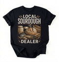 Flat lay of a black local sourdough dealer shirt black funny baking t shirt bread lover gift vintage bakery style on a white background 