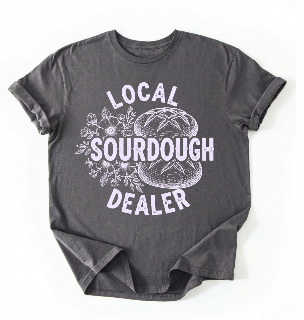 Flat lay of a charcoal local sourdough dealer shirt brown funny baking t shirt bread lover gift bakery humor on a white background 