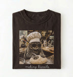 Flat lay of a brown making biscuits cat shirt with chef cat kneading dough funny baker and cat lover gift on a white background 