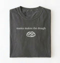 Flat lay of a military green Funny Mama Makes The Dough shirt with bread graphic on brown tee on a white background