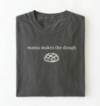 Flat lay of a military green Funny Mama Makes The Dough shirt with bread graphic on brown tee on a white background