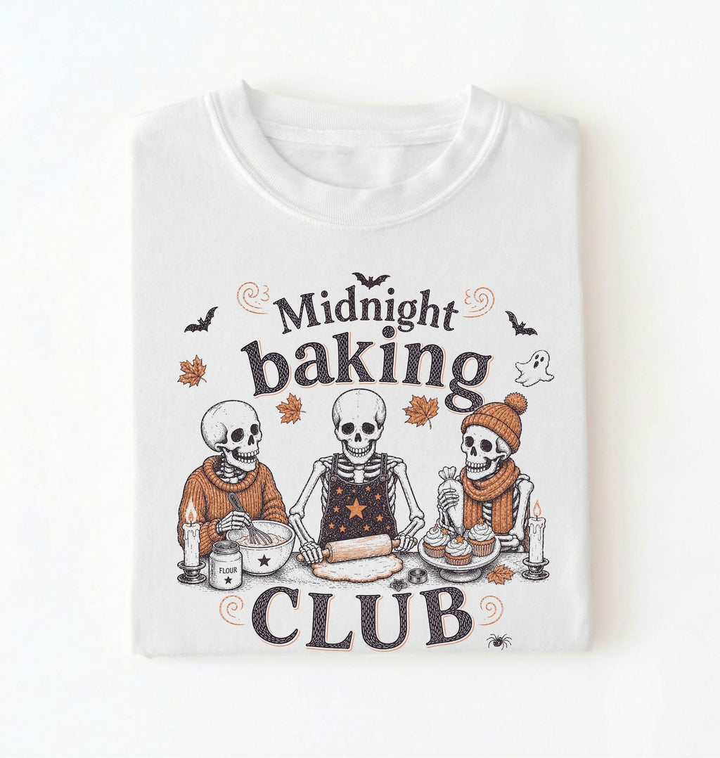 A white short-sleeve t-shirt with a Halloween-themed graphic print that reads 'Midnight baking CLUB' featuring three cartoon skeletons baking together.