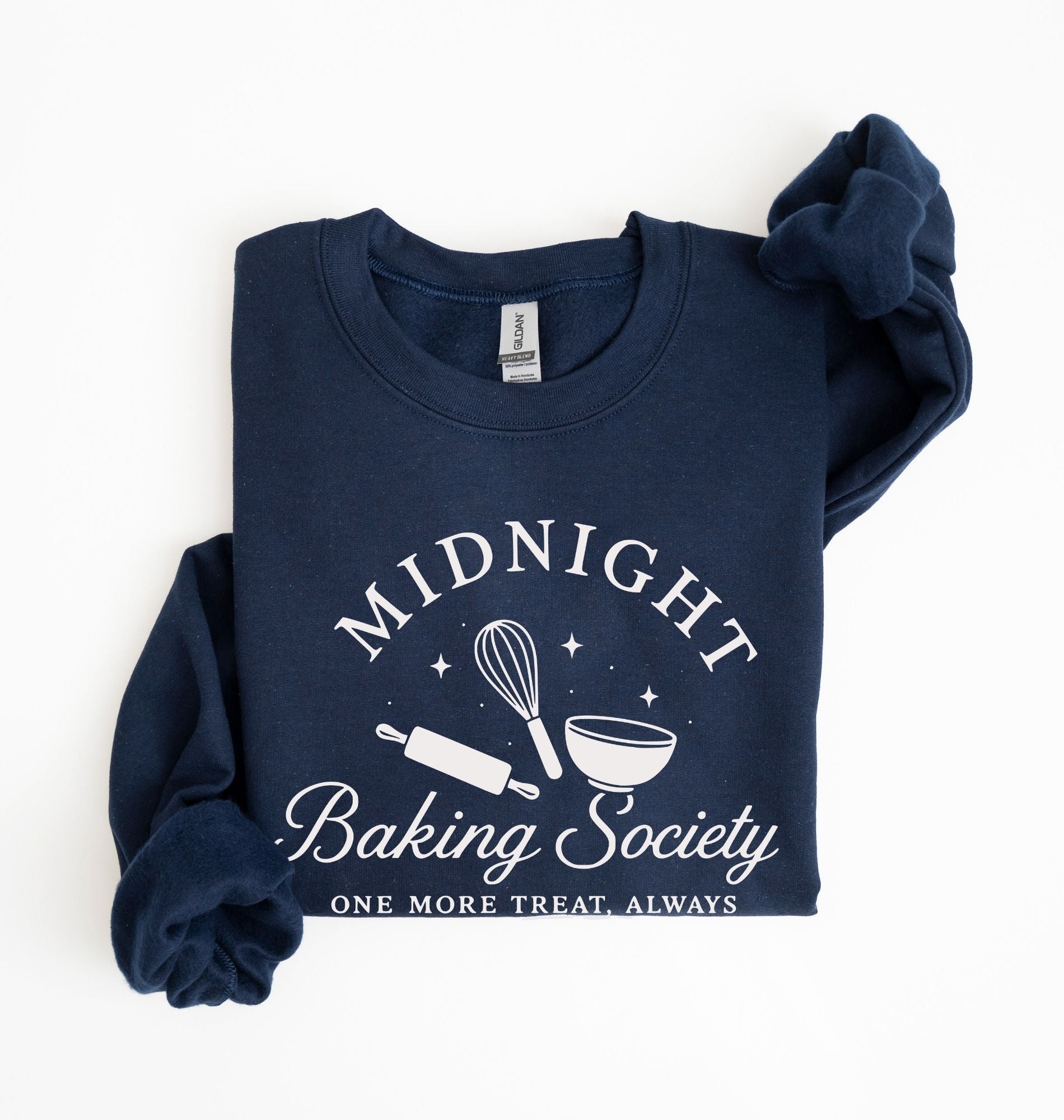 Flat lay of a navy blue Gildan sweatshirt featuring a rolling pin, whisk and mixing bowl with the phrase Midnight Baking Society