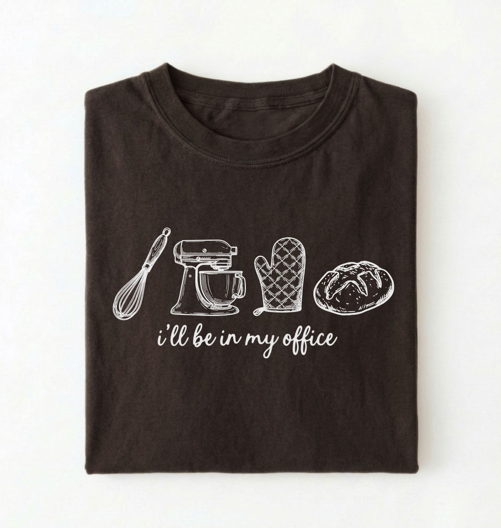 Flat lay of a dark chocolate Minimalist baking shirt with kitchen tools line art and ill be in my office text perfect gift for bakers on a white background 