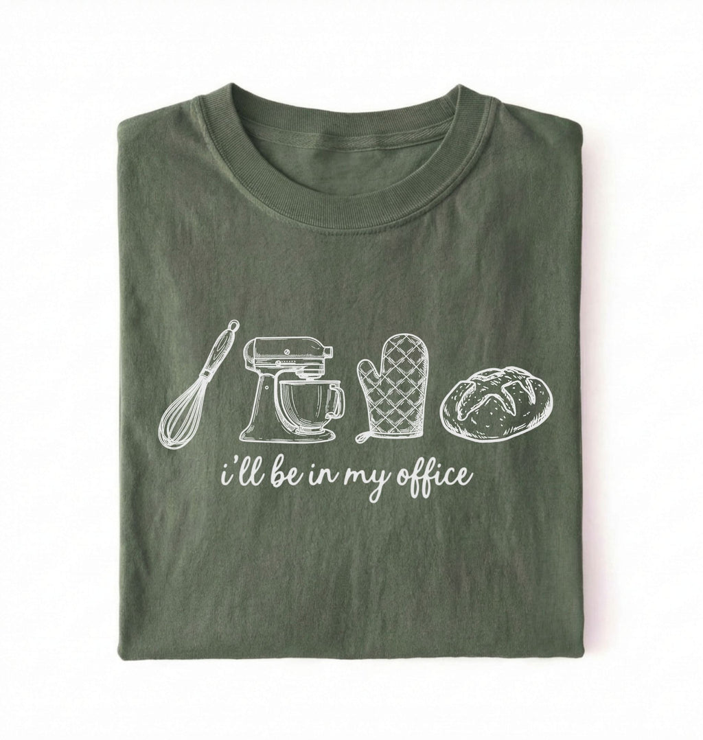 Flat lay of an ivory Minimalist baking shirt with kitchen tools line art and ill be in my office text perfect gift for bakers on a white background 
