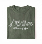 Flat lay of an ivory Minimalist baking shirt with kitchen tools line art and ill be in my office text perfect gift for bakers on a white background 