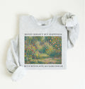 Flat lay of a light gray crewneck sweatshirt on a white background, featuring an impressionist floral garden artwork and black text reading “Money doesn’t buy happiness, but it buys plants, so close enough.