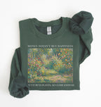 Flat lay of a forest green crewneck sweatshirt on a white background, featuring an impressionist floral garden artwork and black text reading “Money doesn’t buy happiness, but it buys plants, so close enough.”
