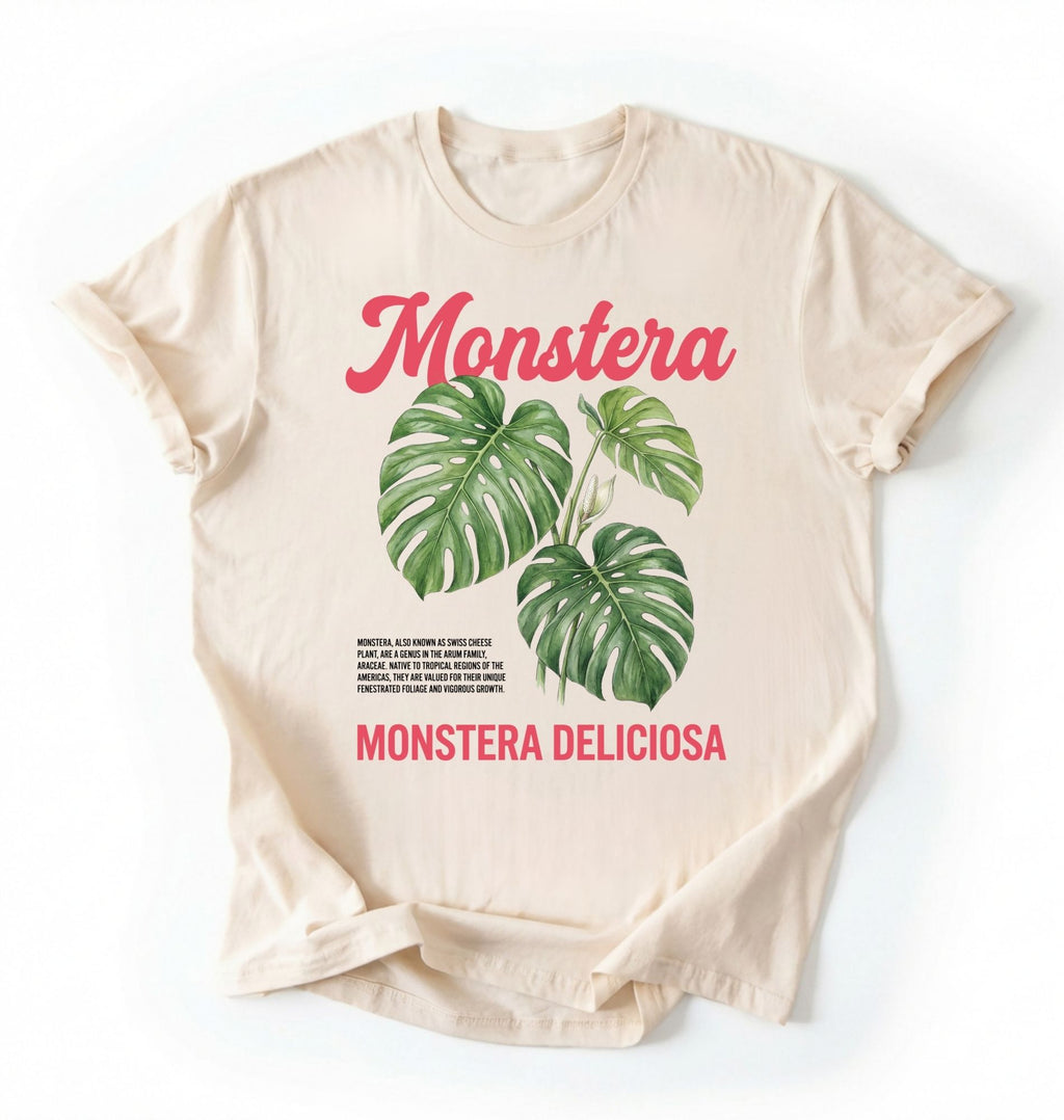 Flat lay of a natural t-shirt featuring a botanical illustration of Monstera leaves with text reading “Monstera Deliciosa.” plant shirt with tropical leaf illustration perfect gift for plant lovers and houseplant enthusiasts on a white background