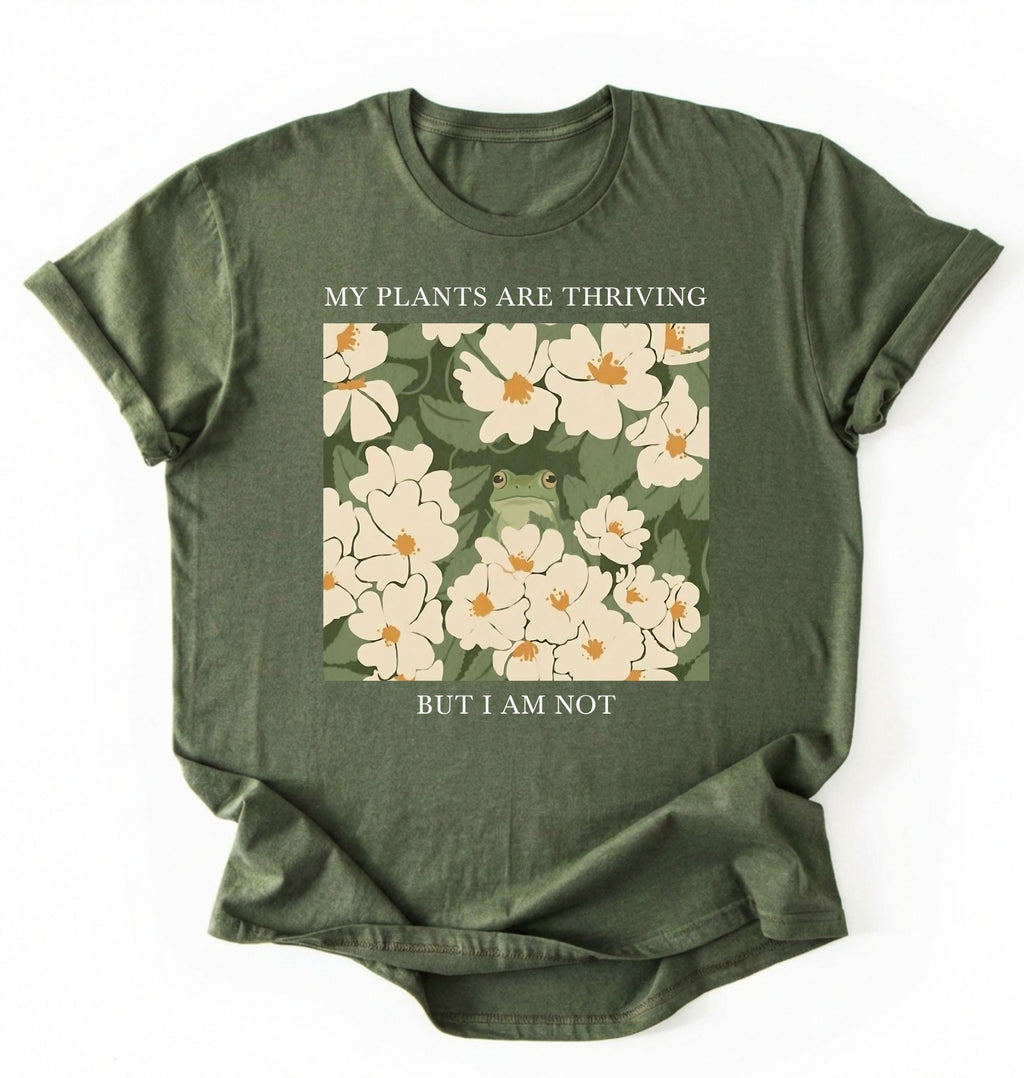 Flat lay of a moss Gardener t-shirt with floral design and text my plants are thriving but i am not plant lover gift on a white background 
