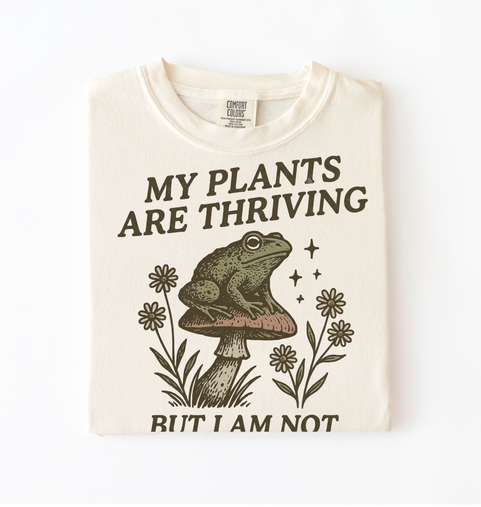 Ivory Comfort Colors shirt with frog sitting on mushroom and text my plants are thriving but I am not