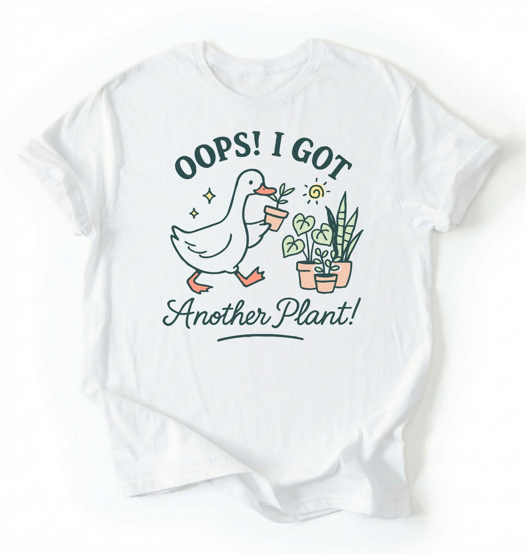 Flat lay white t-shirt with a graphic of a duck holding a plant and text 'Oops! I got another plant!' on a white background