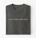 Flat lay pepper t-shirt with 'oops, I bought another plant' with humorous text on a white background