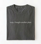 Flat lay pepper t-shirt with 'oops, I bought another plant' with humorous text on a white background