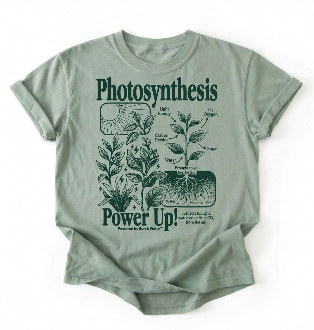 Flat lay of a Bay_Sage t-shirt featuring a botanical diagram with text reading “Photosynthesis Power Up.” for plant lovers and science fans perfect gardening gift for biology teachers and nature enthusiasts on a white background  