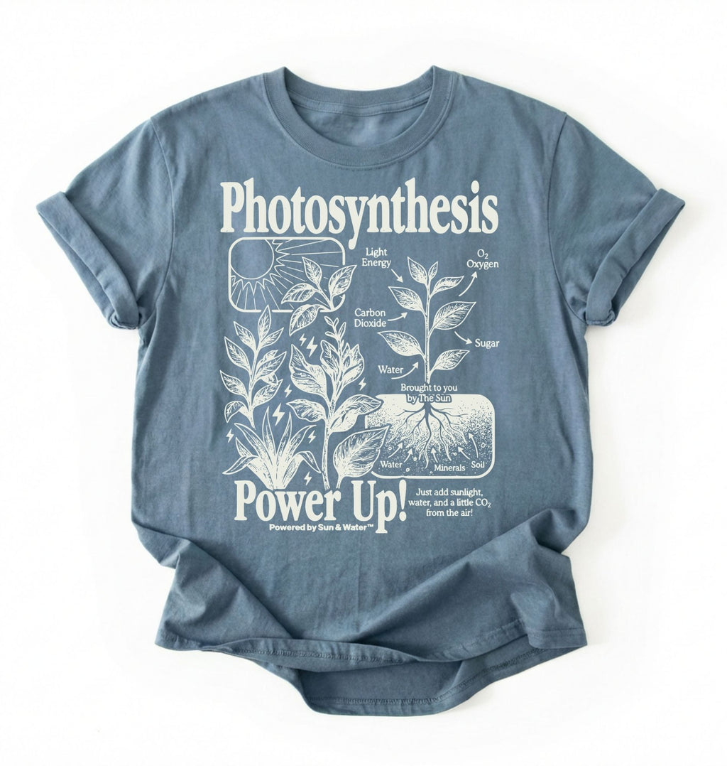 Flat lay of a stoneblue t-shirt featuring a botanical diagram with text reading “Photosynthesis Power Up.” for plant lovers and science fans perfect gardening gift for biology teachers and nature enthusiasts on a white background  