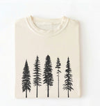 Flat lay of an ivory t-shirt with white pine tree forest graphic, minimalist nature design for hiking and outdoor lovers on a white background
